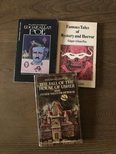 three books sitting on top of a wooden table next to each other and one has a mustache