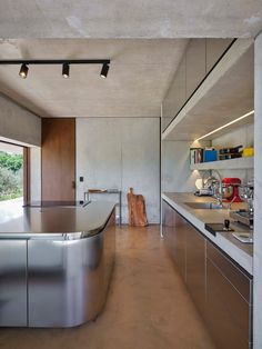 an empty kitchen with stainless steel appliances and counter tops, is shown in this image