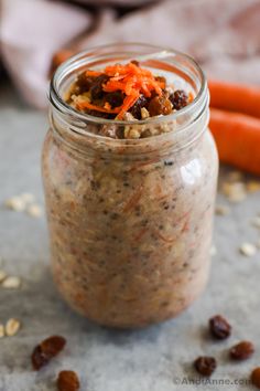 carrots and raisins are in a jar with some oats on the side