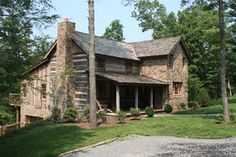 an old log cabin sits in the middle of a wooded area, surrounded by trees