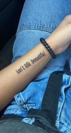 a person with a tattoo on their arm that says, isn't life beautiful