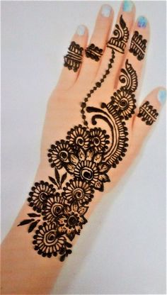 a woman's hand with henna tattoos on it