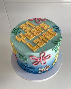 a birthday cake with the words happy birthday written in gold and blue frosting on top