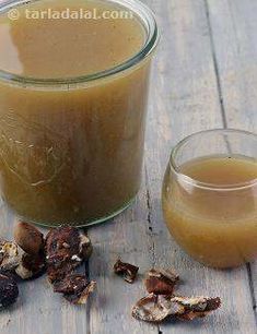 a glass cup filled with liquid next to some nuts