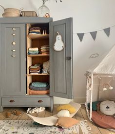 an armoire in the corner of a room filled with toys and other things on display