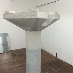 a concrete sculpture is in the middle of a room