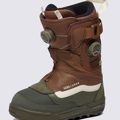 a pair of brown and green snow boots with white soles on the outstep