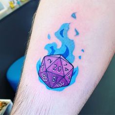 a man's arm with a purple and blue tattoo on it that has the number twenty two dice on it