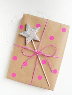 a present wrapped in brown paper with pink polka dots and a silver star on top