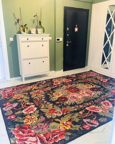 an area rug in the middle of a room with two white cabinets and a black door