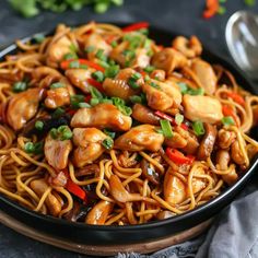 chicken lo mein with noodles and vegetables in a black bowl