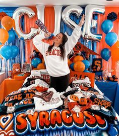 a woman is posing on her bed with balloons and streamers