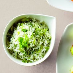 two white bowls filled with food on top of a table