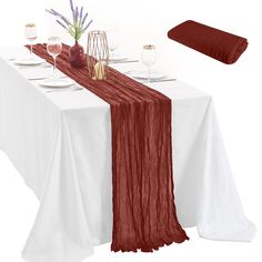 the table is set with wine glasses, plates and napkins for two people to eat