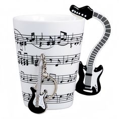 a coffee cup with musical notes on it and a guitar keychain hanging from the side