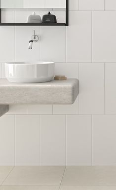 a white sink sitting under a bathroom mirror next to a wall mounted faucet