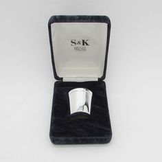 a silver napkin holder in a velvet case with the lid open to show it's contents