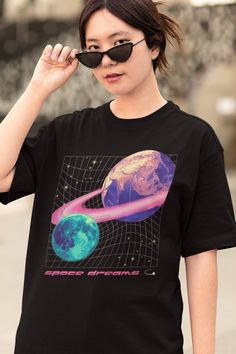 "Design features a pink grid with the earth in pink/purple with a pink ring around it and a blue/aqua moon. Various yellow stars surround them. Below the grid is hot pink text reading \"space dreams\" with a yellow Y2k aesthetic shooting star symbol to the right of the text. Bella Canvas Jersey Tee Info ∙ Tees are made in Los Angeles, CA. Our print partners are also located in the U.S.A. ∙ 100% combed and ring-spun cotton (heather color info listed below) ∙ Lightweight, soft fabric. Side seams a Pink Y2k Shirt With Graphic Print, Pink Y2k Shirt For Streetwear, Pink Y2k Streetwear Shirt, Pink Y2k Style Shirt For Streetwear, 90s Inspired Pink Relaxed Fit Tops, Vaporwave Fashion, Vaporwave Shirt, Pink Grid, Yellow Y2k