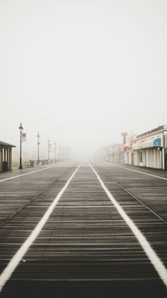 a foggy street with railroad tracks in the foreground