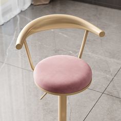 a pink chair sitting on top of a marble floor