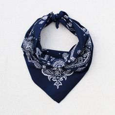 a blue bandana with white designs on it sitting on a table next to a wall