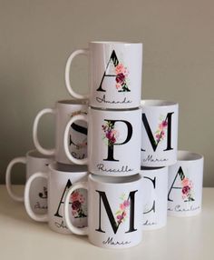 a stack of coffee mugs sitting on top of a white table next to each other