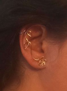 a close up of a person's ear with two gold rings attached to it