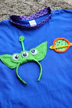 a child's blue t - shirt with an image of a green leaf on it