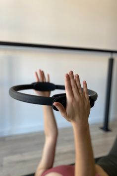 a woman laying on the floor with her hands in the air and holding onto a black object