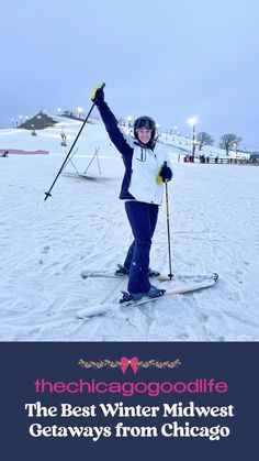 a woman on skis holding her arms up in the air while posing for a photo