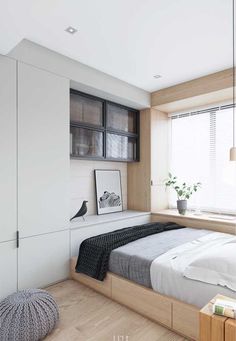 a bedroom with white walls and wooden floors