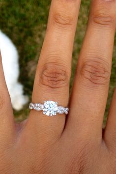 a woman's hand with a diamond ring on it