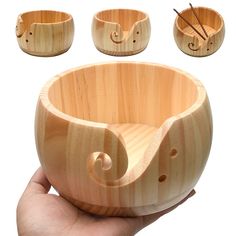 a hand holding a wooden bowl with four different bowls around it