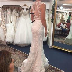 a woman is looking at her wedding dress in the mirror