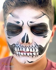 a young boy with his face painted in black and white