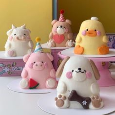 there are many small cakes that look like animals on the cake stand, and one has a birthday hat on it