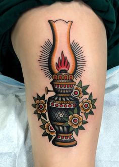 a woman's leg with a tattoo on it that has an image of a vase and flowers