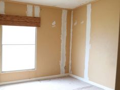 an empty room with white paint on the walls and drywalling around the window