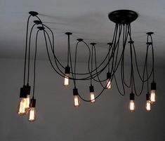 a chandelier with many light bulbs hanging from it's sides and wires attached to the ceiling