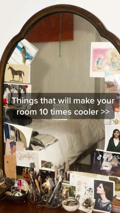 a mirror sitting on top of a wooden dresser filled with pictures and other items next to a bed