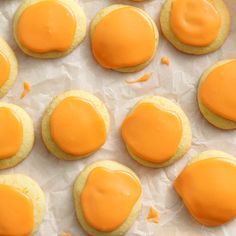 there are many cookies with orange icing on them