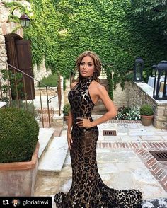 a woman in a leopard print dress posing for the camera