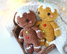 two crocheted teddy bears sitting next to each other in a basket under a christmas tree