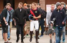 a group of men walking down a street next to each other