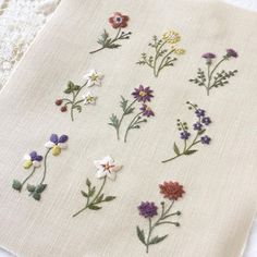 several embroidered flowers are displayed on a piece of cloth