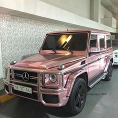 a pink mercedes g - class parked in a garage