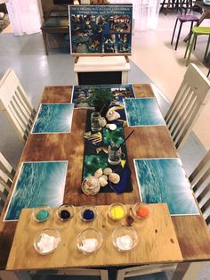 a wooden table topped with lots of paint and watercolors on top of it