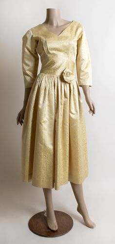 "FREE DOMESTIC SHIPPING! <3 ♥ Lovely vintage 1950s light golden yellow party dress! ♥ Metal zipper on the side. Classic V-neckline in front and back. Half length sleeve. ♥ Fitted waist with a rose flower on the hip! ♥ Fun velvety squiggle abstract design! Reminds me of faux bois. ♥ In very good condition! There are some markings and discoloration spots on the skirt. See photos. A cluster of them near the back of the waist, and a few small spots on the skirt, some on the squiggles, some are li Yellow Vintage Dress For Vintage Events, 1950s Style Vintage Yellow Dress For Spring, Yellow Fitted Vintage Dress 1950s Style, Yellow Party Dresses, Yellow 50’s Dress, Yellow Vintage Dress, 1950s Style For Spring, Yellow Satin, Vintage Dresses 1960s, Garden Party Dress