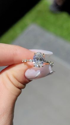 a woman's hand holding an engagement ring