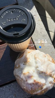 a donut sitting on top of a wooden table next to a cup of coffee